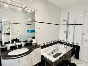 a bathroom with a sink and a bath tub at Joli appartement spacieux à 3 min à pied de la mer in Nice