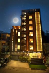 a tall building with lights on it at night at Sai Maa Hotel & Residency in Puttaparthi