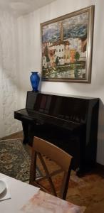 a piano in a living room with a painting on the wall at Hotel Villa Pagoda in Sirmione