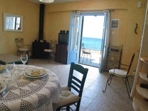 comedor con mesa y vistas al océano en Kyparissis Beach Houses, en Skala Mistegnon
