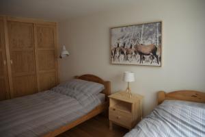 a bedroom with two beds and a picture on the wall at Chalet 3 chambres à Sarreyer, proche Verbier in Sarreyer