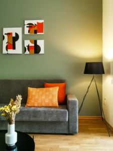 sala de estar con sofá gris y almohada naranja en Phaedrus Living City View Luxury Iras Flat 102, en Nicosia