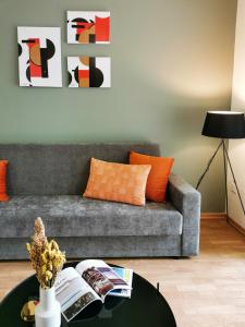 a living room with a gray couch and orange pillows at Phaedrus Living City View Luxury Iras Flat 102 in Nicosia