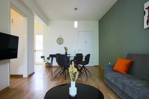 sala de estar con sofá y mesa con sillas en Phaedrus Living City View Luxury Iras Flat 102, en Nicosia