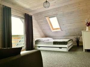 um quarto com uma cama, uma janela e um sofá em Białe Domki Lubiatowo em Lubiatowo