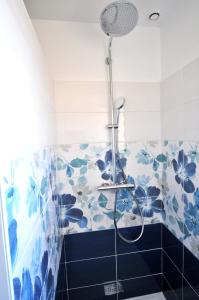 a shower in a bathroom with blue and white tiles at Gîte de Catherine in Saint-Didier