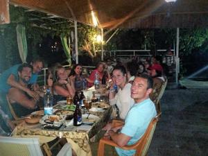a group of people sitting around a table eating at Rose Hotel B&B in Patara