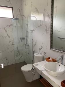 ein Badezimmer mit Toilette, Waschbecken und Dusche in der Unterkunft Platinum Dago Resort villa 15px Private Pool Bandung in Bengkok