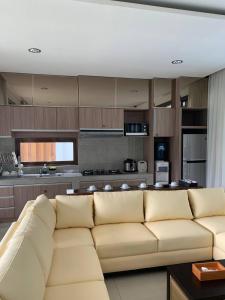 ein Wohnzimmer mit Couch und Küche in der Unterkunft Platinum Dago Resort villa 15px Private Pool Bandung in Bengkok