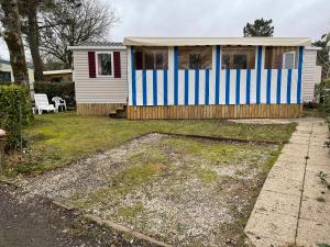 a small house with blue and white stripes on it at Mobil home Domaine de Kerlann in Pont-Aven