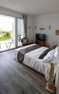 a bedroom with a large bed and a large window at Superbe appart.T2 face à la mer à Tréboul Douarnenez in Douarnenez