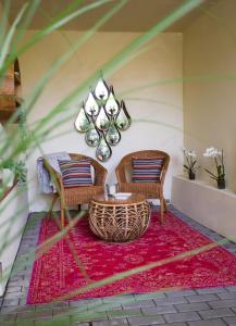 a room with two chairs and a table on a red rug at Ruhe-Zone in Stemwede