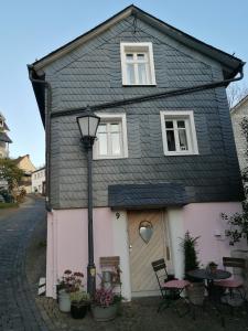 a small house with a black roof and a door at Siegen Altstadt Oberstadt Häuschen in Siegen