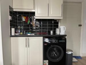 eine Küche mit einer Waschmaschine in der Unterkunft Studio Flat London Finchley Rd NW11 in London