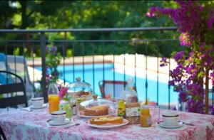 - une table avec de la nourriture et des boissons à côté de la piscine dans l'établissement LA POIANA, à Pignerol