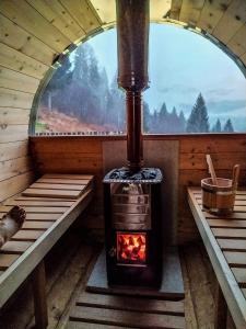 a wood stove in a room with a window at Baita Zeni Tirolerhof - Adult friendly in Fiera di Primiero