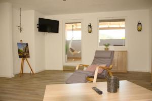 a living room with a couch and a chair at Gästehaus Mittendrin in Dahn