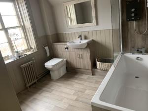 a bathroom with a toilet and a sink and a tub at The Stair Arms Hotel in Edinburgh