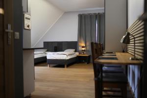 Cette chambre comprend deux lits, un bureau et une table. dans l'établissement A&B Willa Klaudyny, à Varsovie