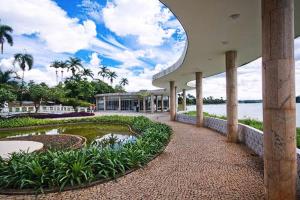 um grande edifício com um lago em frente em Flat com Varanda-Pampulha em Belo Horizonte