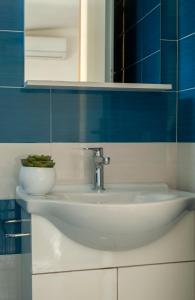 a white sink in a bathroom with blue tiles at Casa Palinuro Vacanze in Palinuro