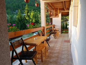 a porch with wooden tables and chairs and flowers at Vila Borovi in Zaovine