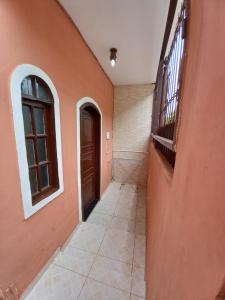 um corredor de uma casa com uma porta e um piso de azulejo em Suíte Pegadas na Areia em Arraial do Cabo