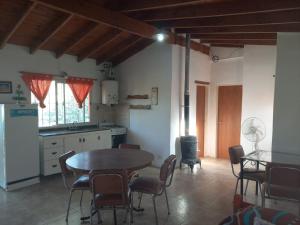 a kitchen and dining room with a table and chairs at Complejo Los Sauces in Mina Clavero