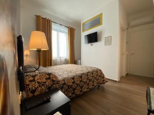 a bedroom with a bed and a lamp and a window at Affittacamere San Michele in San Benedetto del Tronto