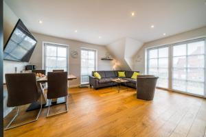 a living room with a couch and a table at Südstrandhus Urlaub mit Hund Wohnung 3 oben in Borkum