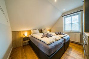 a bedroom with a large bed with a window at Südstrandhus Urlaub mit Hund Wohnung 3 oben in Borkum