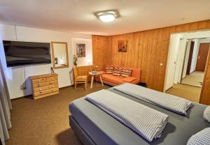 a bedroom with two beds and a couch and a table at Landhotel Krone in Oberreute