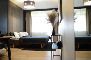 um quarto com uma cama, uma mesa e uma janela em Palanga-Apartamentai em Palanga