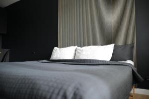 um quarto com uma cama com paredes pretas e almofadas brancas em Palanga-Apartamentai em Palanga