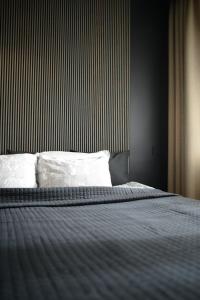 uma cama num quarto com uma parede listrada em Palanga-Apartamentai em Palanga