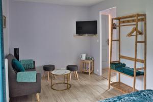 a bedroom with a bunk bed and a living room at LA Jacarandière in Le Cambout