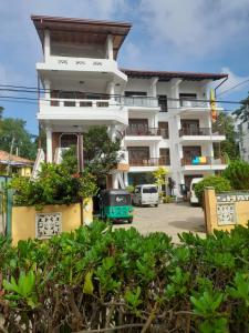 a building with a green van parked in front of it at Shanika Beach Inn in Tangalle
