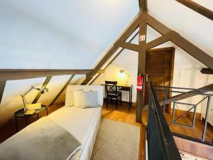 a bedroom with a bed and a desk in a attic at Juniper Star House - Penhas da Saúde,Serra Estrela in Cortes do Meio