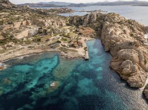 eine Luftansicht auf eine felsige Insel mit blauem Wasser in der Unterkunft Residence Cala Francese - Case sul mare in La Maddalena
