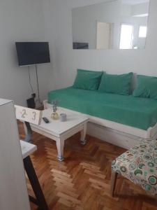 sala de estar con sofá verde y mesa en Botanico 2 ambientes en Buenos Aires