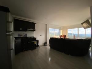 a living room with a kitchen with a large window at CASA TOÑITA in Oiba