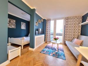 a bedroom with blue walls and a bed and a window at My Beloved Warsaw City Center - NETFLIX in Warsaw