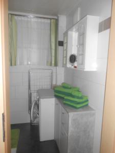 a white bathroom with green towels on a counter at Ferienwohnung Michaela in Flattach