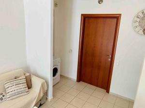 uma sala de estar com uma porta de madeira e um micro-ondas em Aristea’s place Askeli em Poros