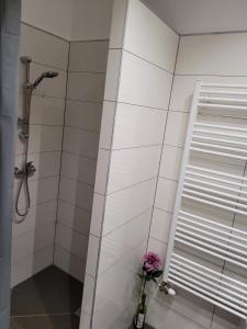 un baño con ducha y una flor en un jarrón en Lovely Apartment with free parking en Kecskemét