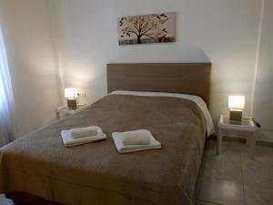 a bedroom with a bed with two towels on it at Maza House in Stavros