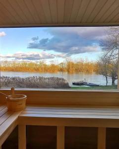 uma janela com vista para um lago e um barco em Vízparti Apartmanház em Leányfalu