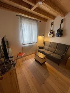 ein Wohnzimmer mit einem Sofa und einem TV in der Unterkunft Ferienturm zur ehemal. Umspannstation Poppenroth in Bad Kissingen