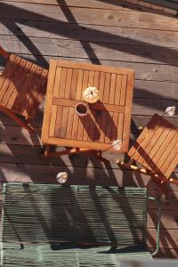 a wooden table with a cup and two chairs at Ferienturm zur ehemal. Umspannstation Poppenroth in Bad Kissingen