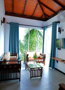 Ranil Villa في غالي: غرفة معيشة بها كنبتين وطاولة زجاجية